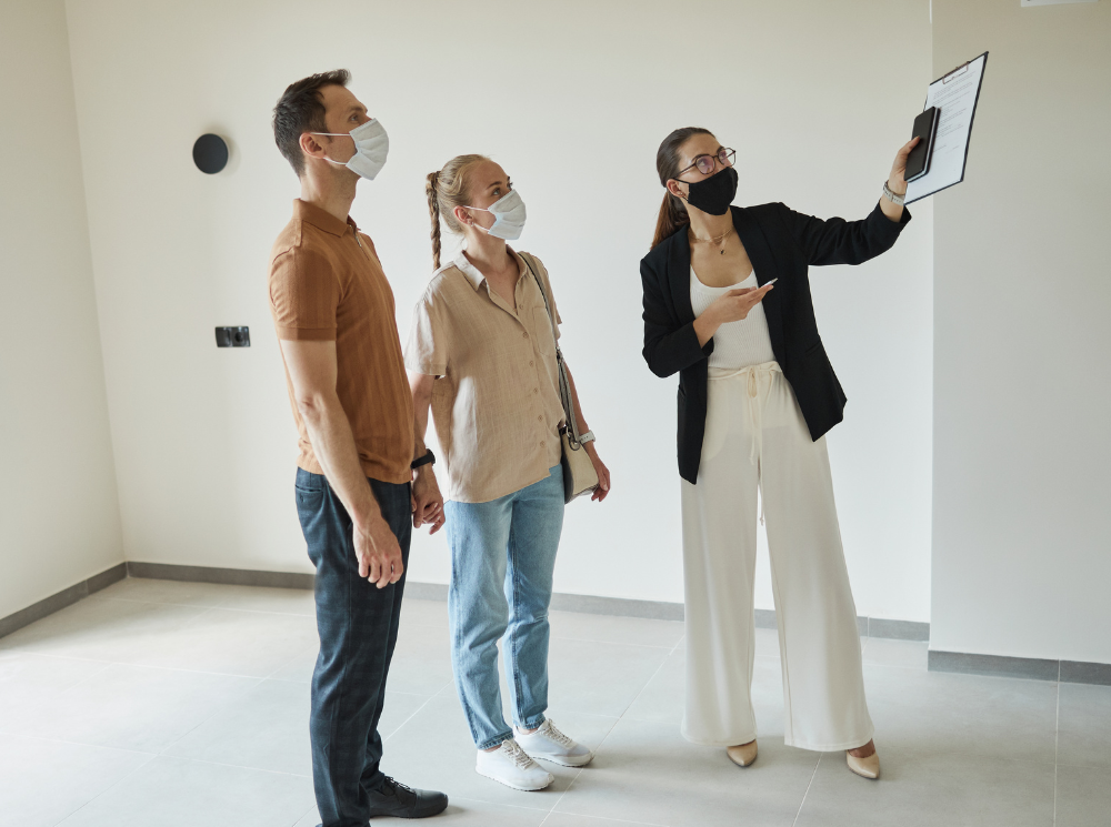 A couple is looking at a blank canvas for the installation of a wall-mounted comfort control electric radiator.