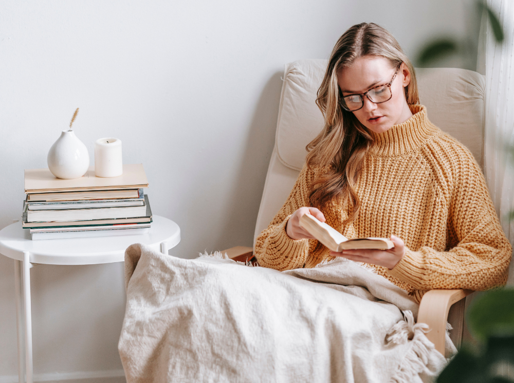 A woman is enjoying a peaceful moment in her living room as she reads.