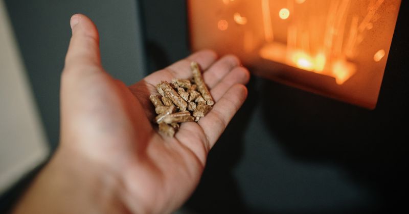 A man burning biomass pellet fire.