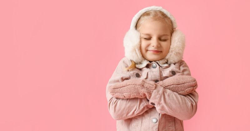 A child wearing thick clothing during the winter season.