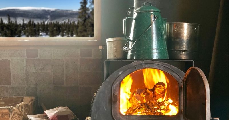 Wood burning on a stove near the window.