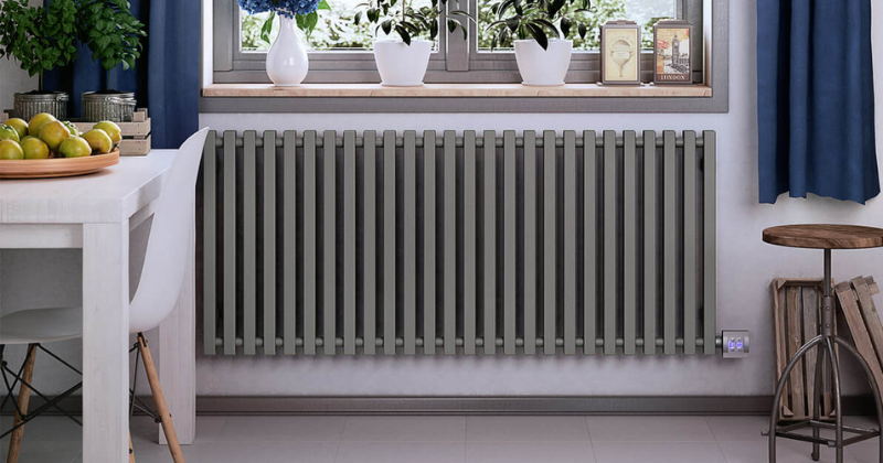 White wall-mounted electric radiator near an elegant staircase.