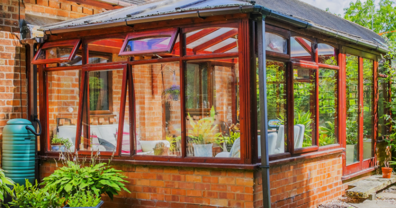 Bright red casement windows adorn the conservatory room.