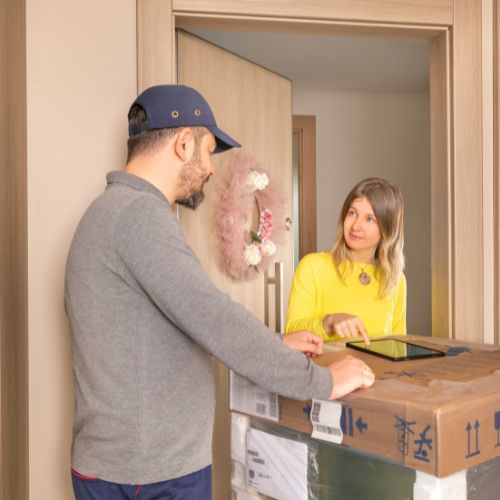 Delivery man brings electric radiator to home.